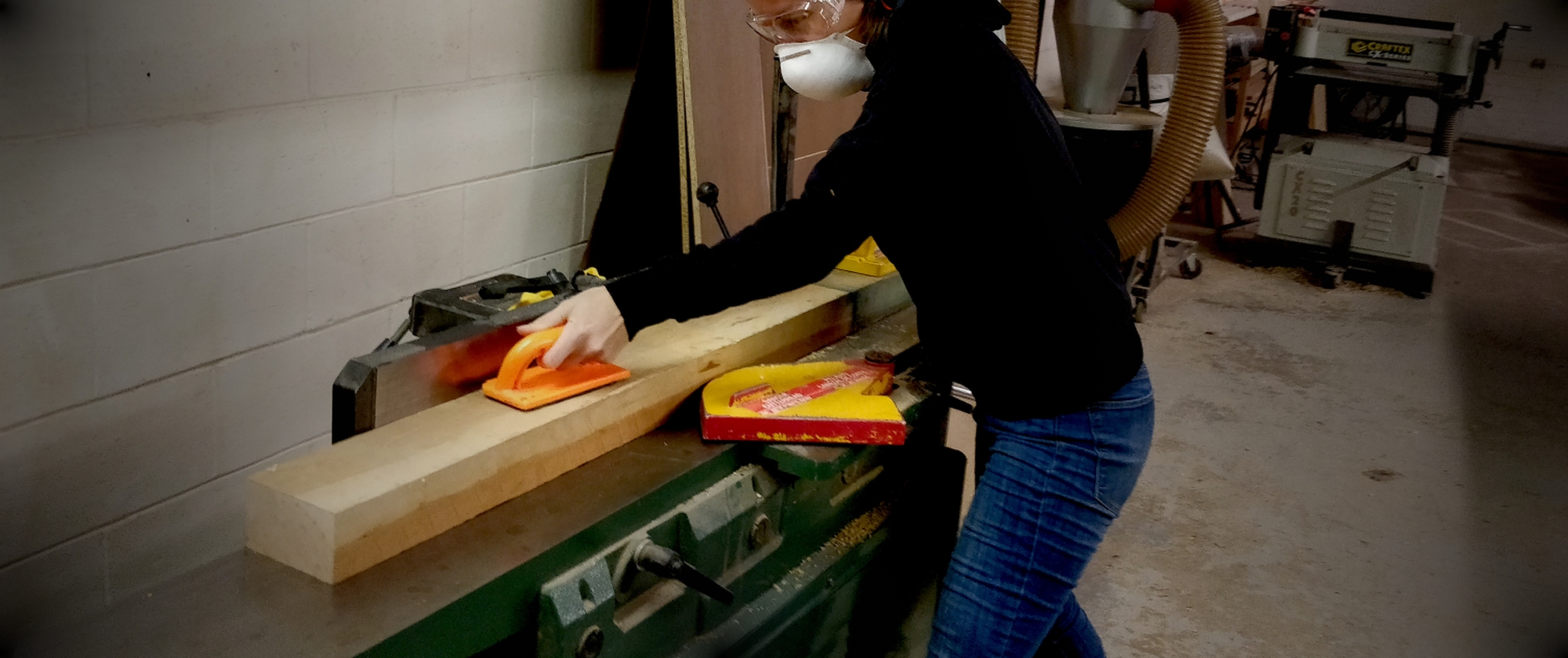 Woman woodworker working with Cherry hardwood lumber on a jointer machine